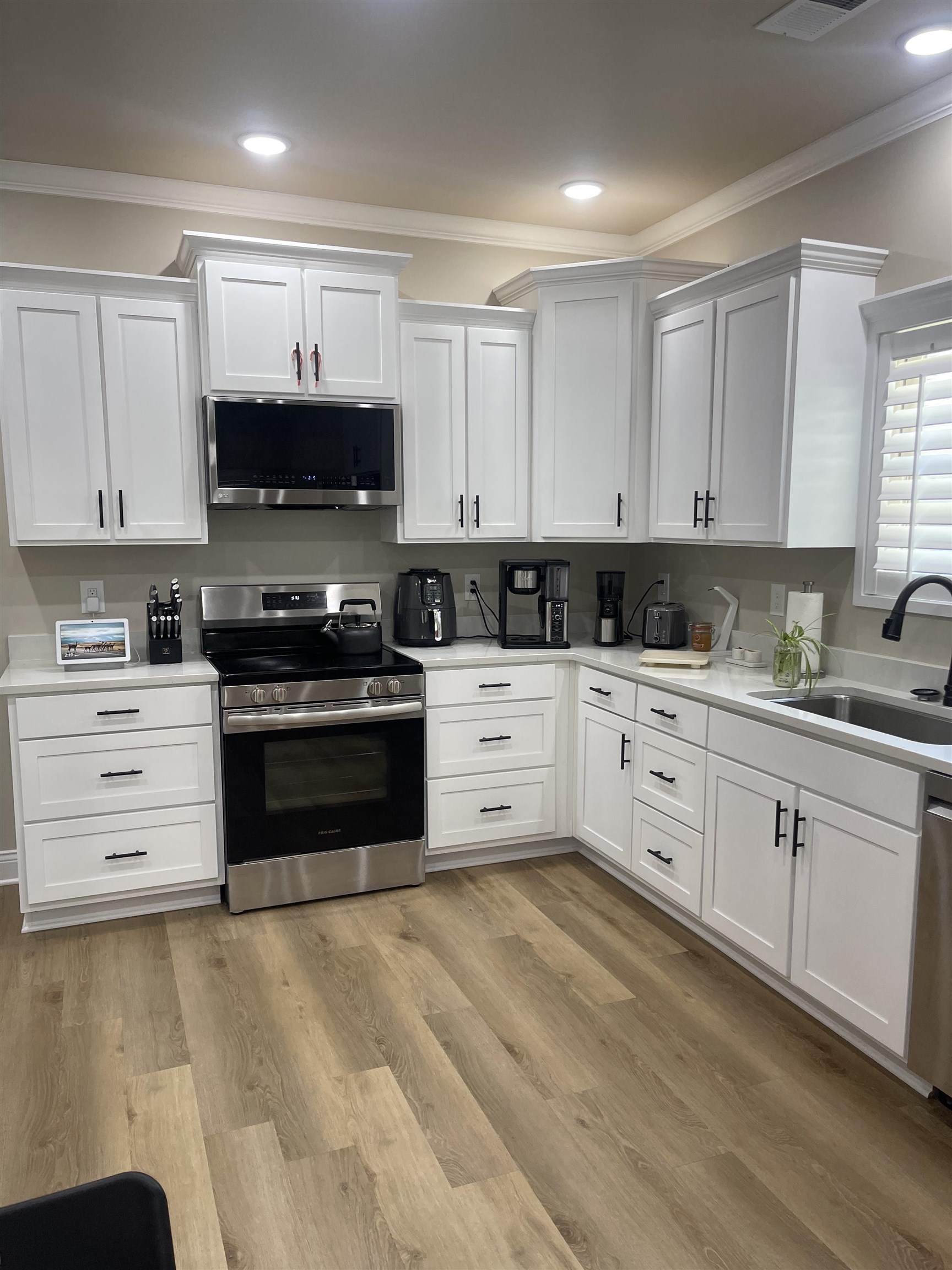 210 Church Street Ripley, TN 38063 - Photo 7 of 21 Kitchen with stainless steel appliances, white cabinetry, light wood-style floors, ornamental molding, and recessed lighting