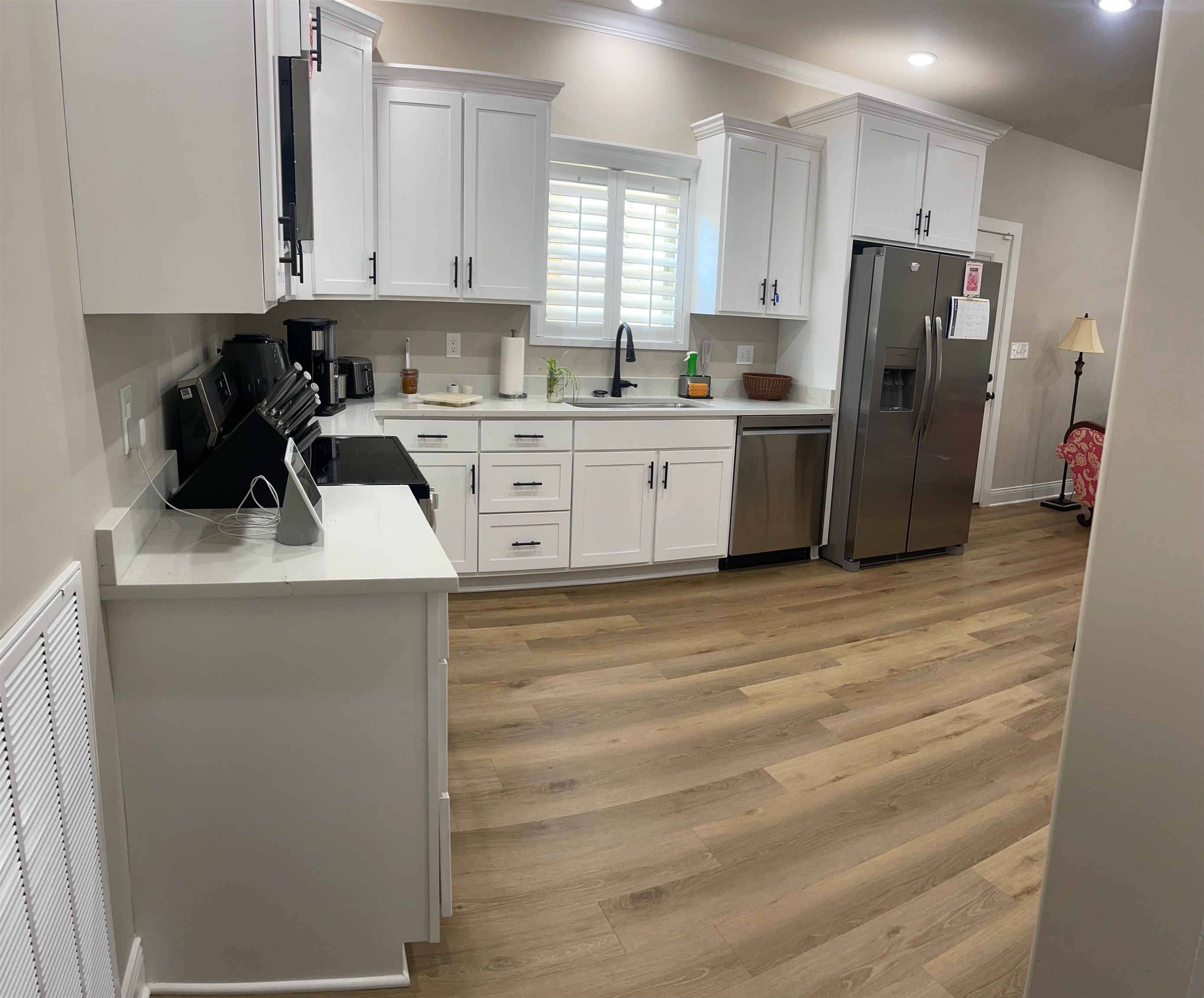 210 Church Street Ripley, TN 38063 - Photo 8 of 21 Kitchen featuring white cabinetry, stainless steel appliances, light wood-style floors, light stone countertops, and crown molding