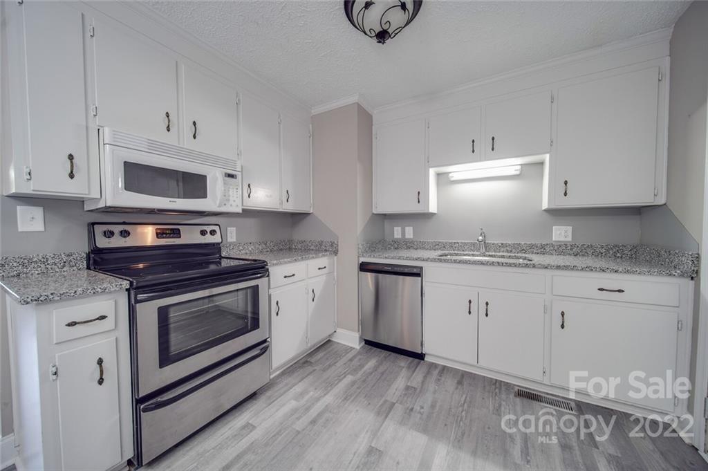 1149 Long Pine Church Road Peachland, NC 28133 - Photo 5 of 27 a kitchen with granite countertop white cabinets and white appliances