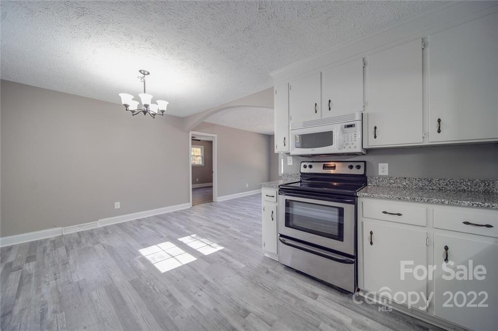 1149 Long Pine Church Road Peachland, NC 28133 - Photo 7 of 27 a kitchen with granite countertop wooden floors a stove and a granite counter tops