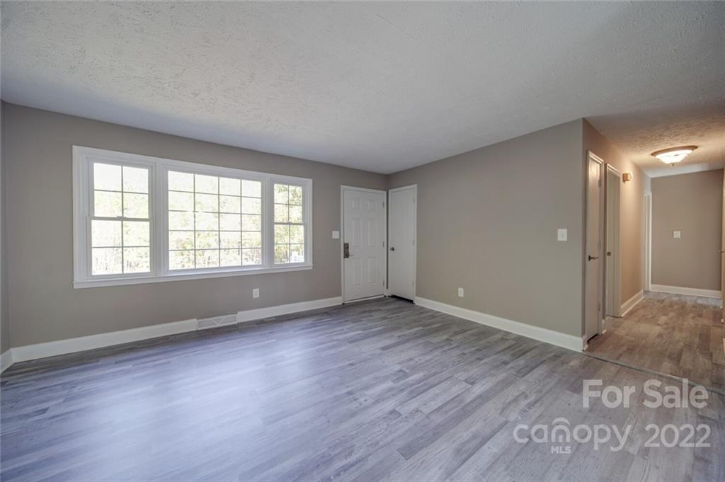 1149 Long Pine Church Road Peachland, NC 28133 - Photo 10 of 27 an empty room with wooden floor and windows