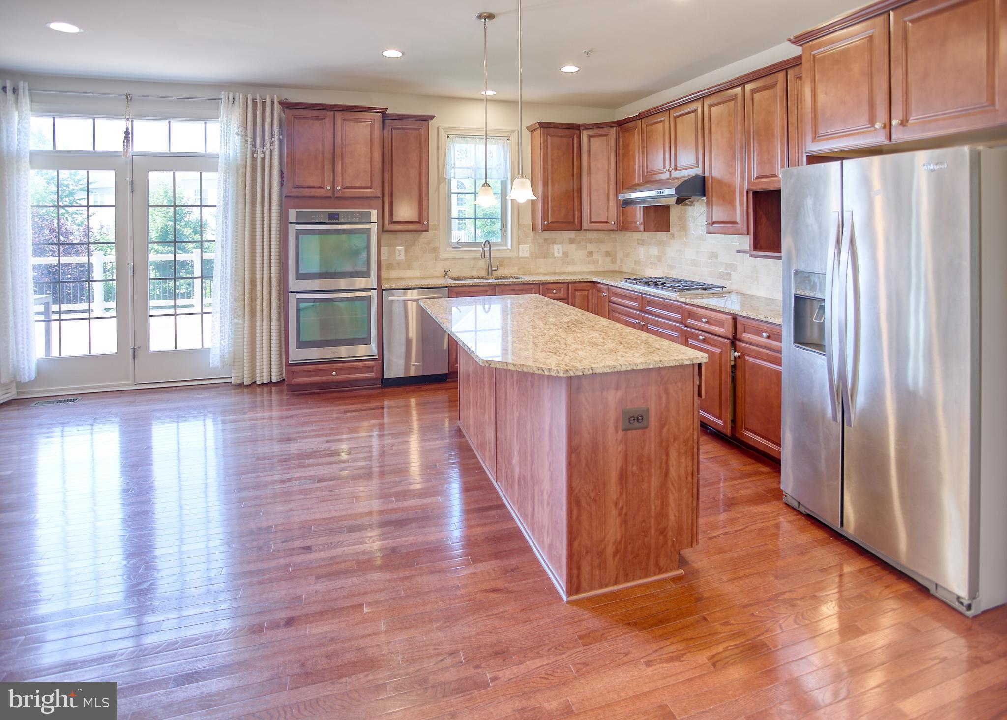 13336 Redspire Drive Silver Spring, MD 20906 - Photo 14 of 66 a kitchen with stainless steel appliances granite countertop a refrigerator a sink and a stove with wooden floor