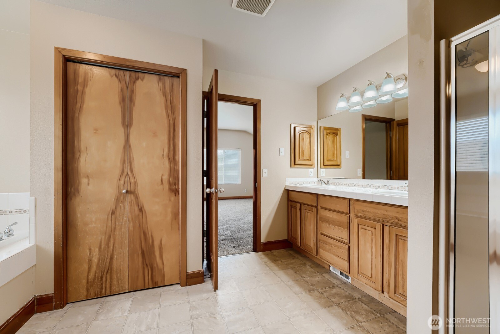 1104 Williams Street Northwest Orting, WA 98360 - Photo 15 of 27 a spacious bathroom with a mirror and a shower