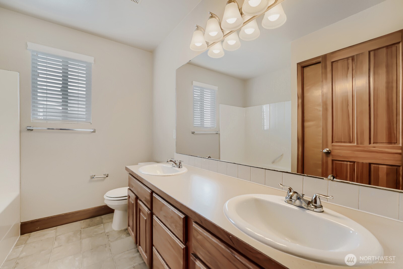 1104 Williams Street Northwest Orting, WA 98360 - Photo 16 of 27 a bathroom with a sink a toilet and a large mirror