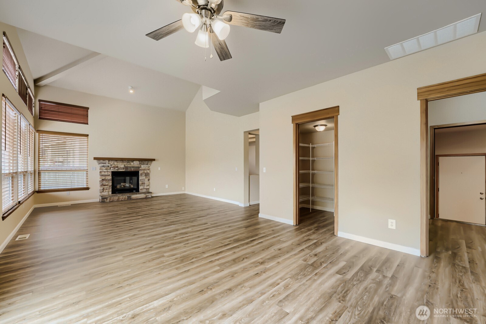 1104 Williams Street Northwest Orting, WA 98360 - Photo 4 of 27 an empty room with wooden floor fireplace and windows