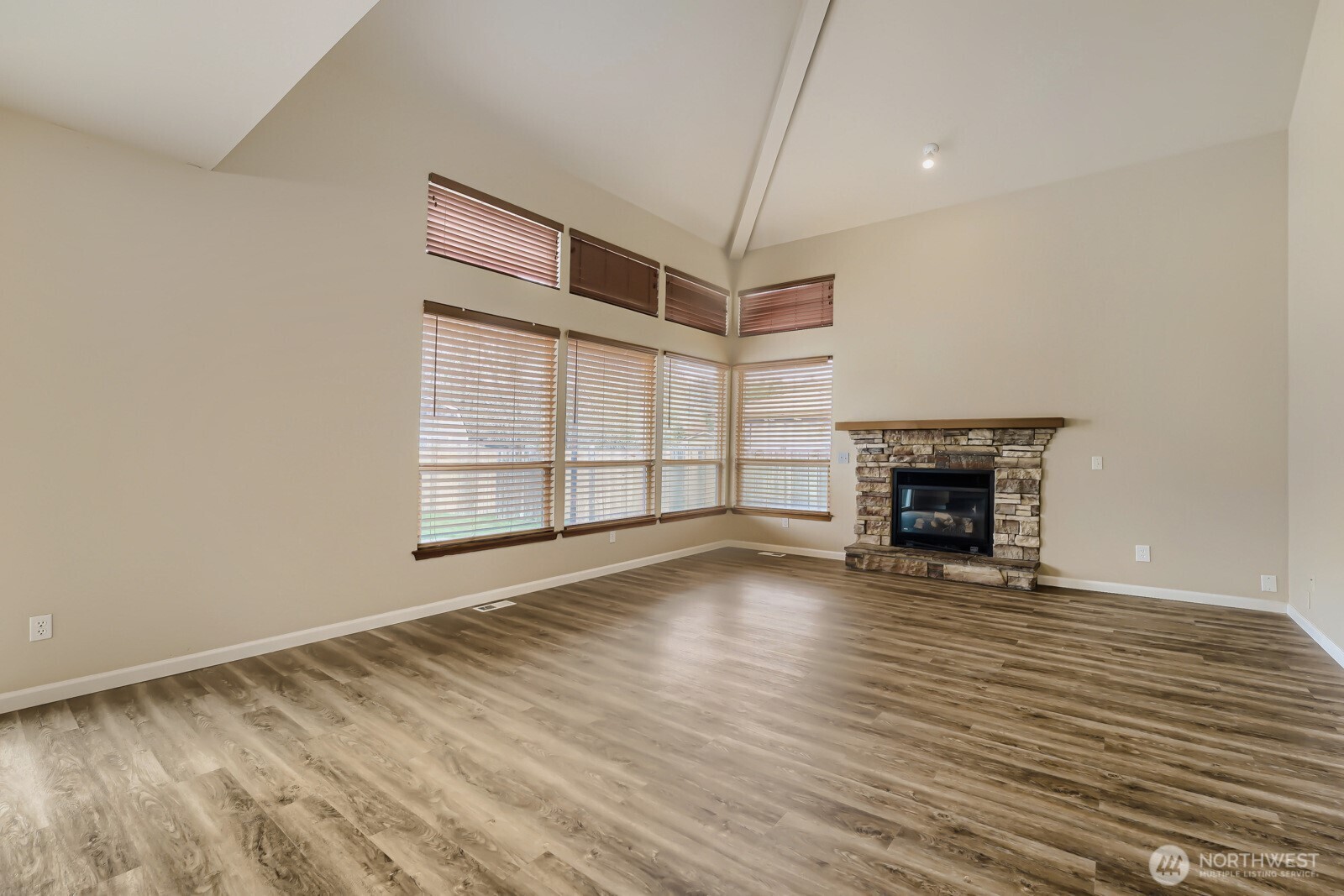 1104 Williams Street Northwest Orting, WA 98360 - Photo 6 of 27 a view of an empty room with wooden floor fireplace and a window
