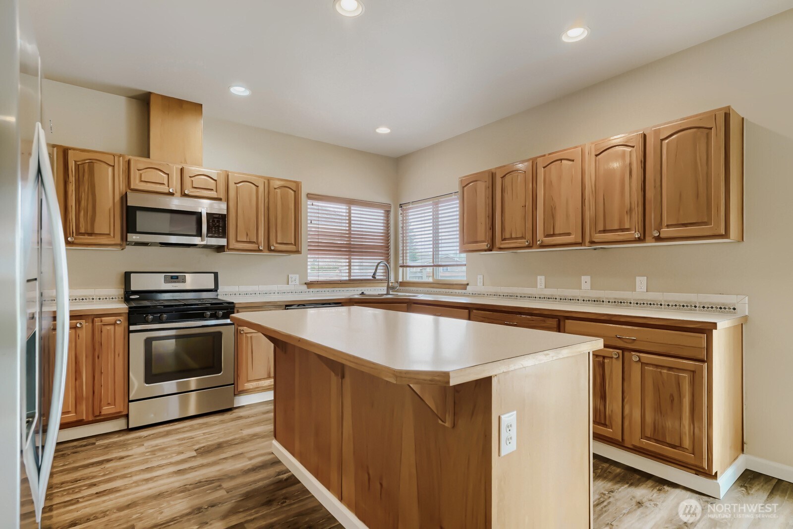 1104 Williams Street Northwest Orting, WA 98360 - Photo 10 of 27 a kitchen with kitchen island granite countertop a sink stove and refrigerator
