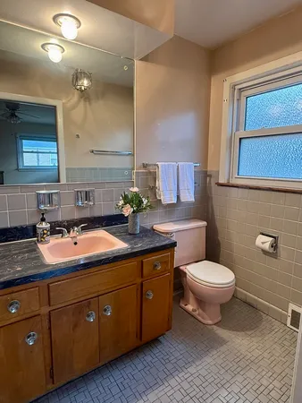 a spacious bathroom with a granite countertop sink and a toilet