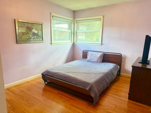 a bedroom with a bed and wooden floor