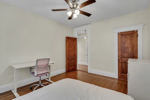 a bedroom with a workspace and a window