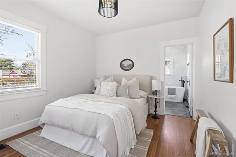 a bedroom with a bed and a painting on the wall