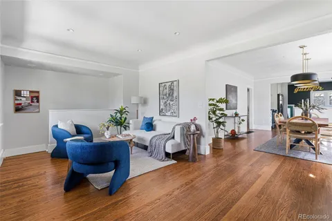 a living room with furniture dining table and a wooden floor