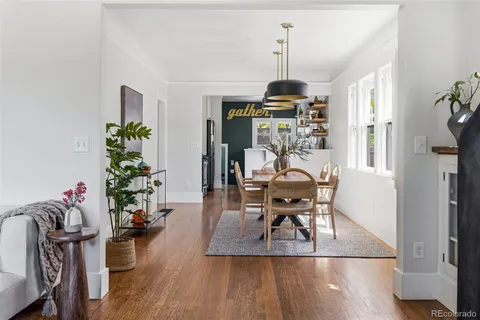 a kitchen with stainless steel appliances granite countertop a sink a window and white cabinets