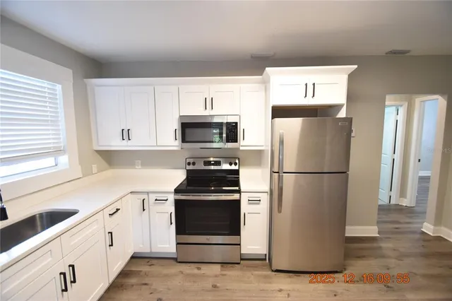 a kitchen with white cabinets and white appliances