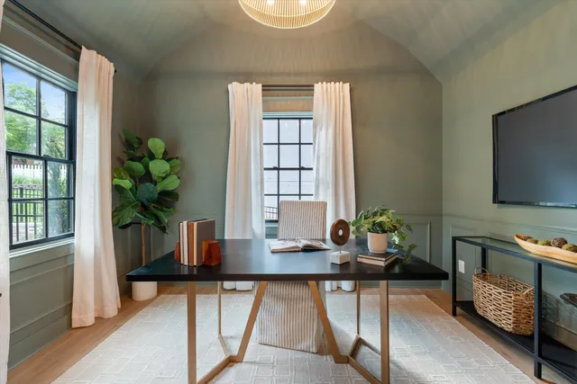 a dining room with furniture a potted plant and a window
