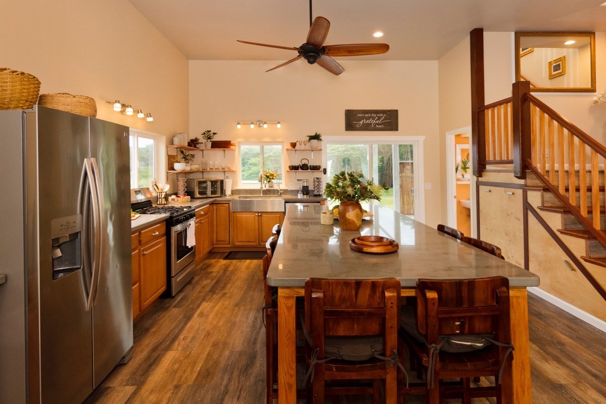 17-3926 Enos Road Mountain View, HI 96771 - Photo 11 of 30 a kitchen with stainless steel appliances granite countertop a dining table chairs refrigerator and sink