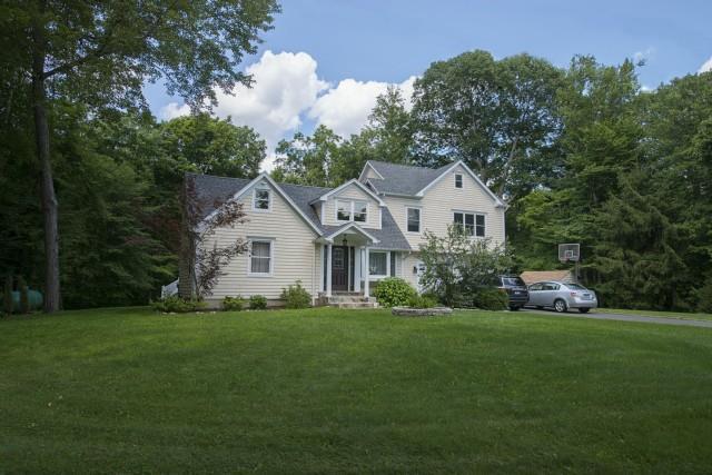 a front view of a house with a garden and trees