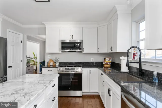 a living room with furniture kitchen view and a large window