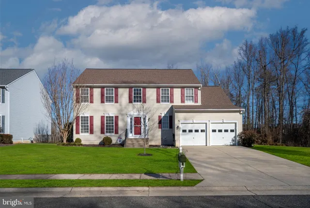 a view of a white house with large windows and a yard