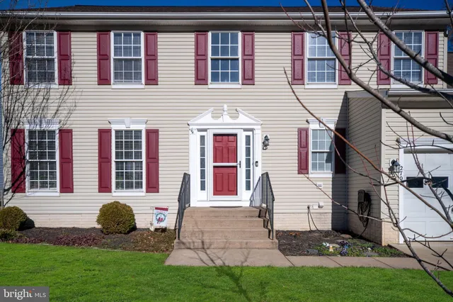 a living room with furniture a wooden floor and a potted plant