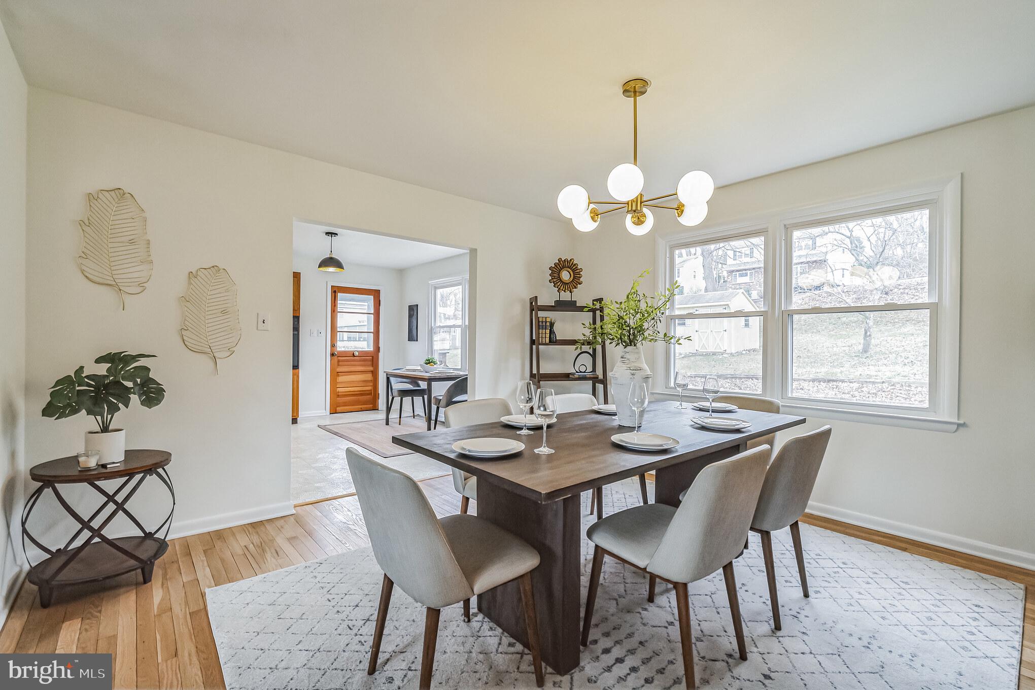 645 Glendale Road Havertown, PA 19083 - Photo 4 of 36 a dining room with wooden floor a chandelier a wooden table and chairs