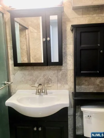 a sink sitting under a bathroom mirror