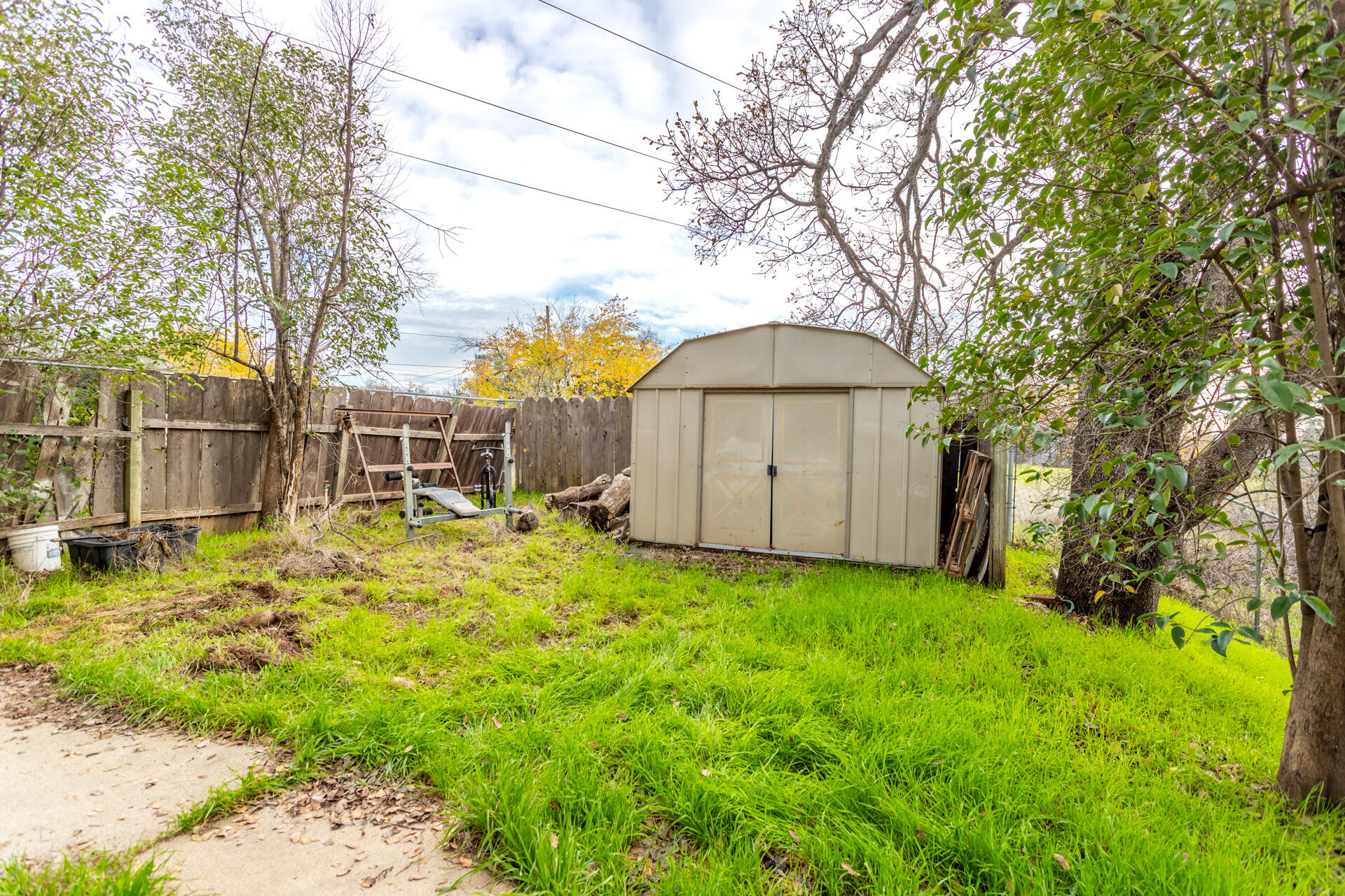 4720 Enchanted Way Redding, CA 96001 - Photo 15 of 19 a view of a backyard with a large tree and wooden fence
