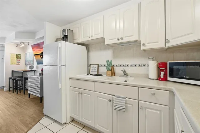a white kitchen with cabinets and stainless steel appliances