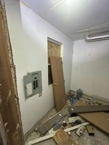 a room with a wooden floor and white appliances