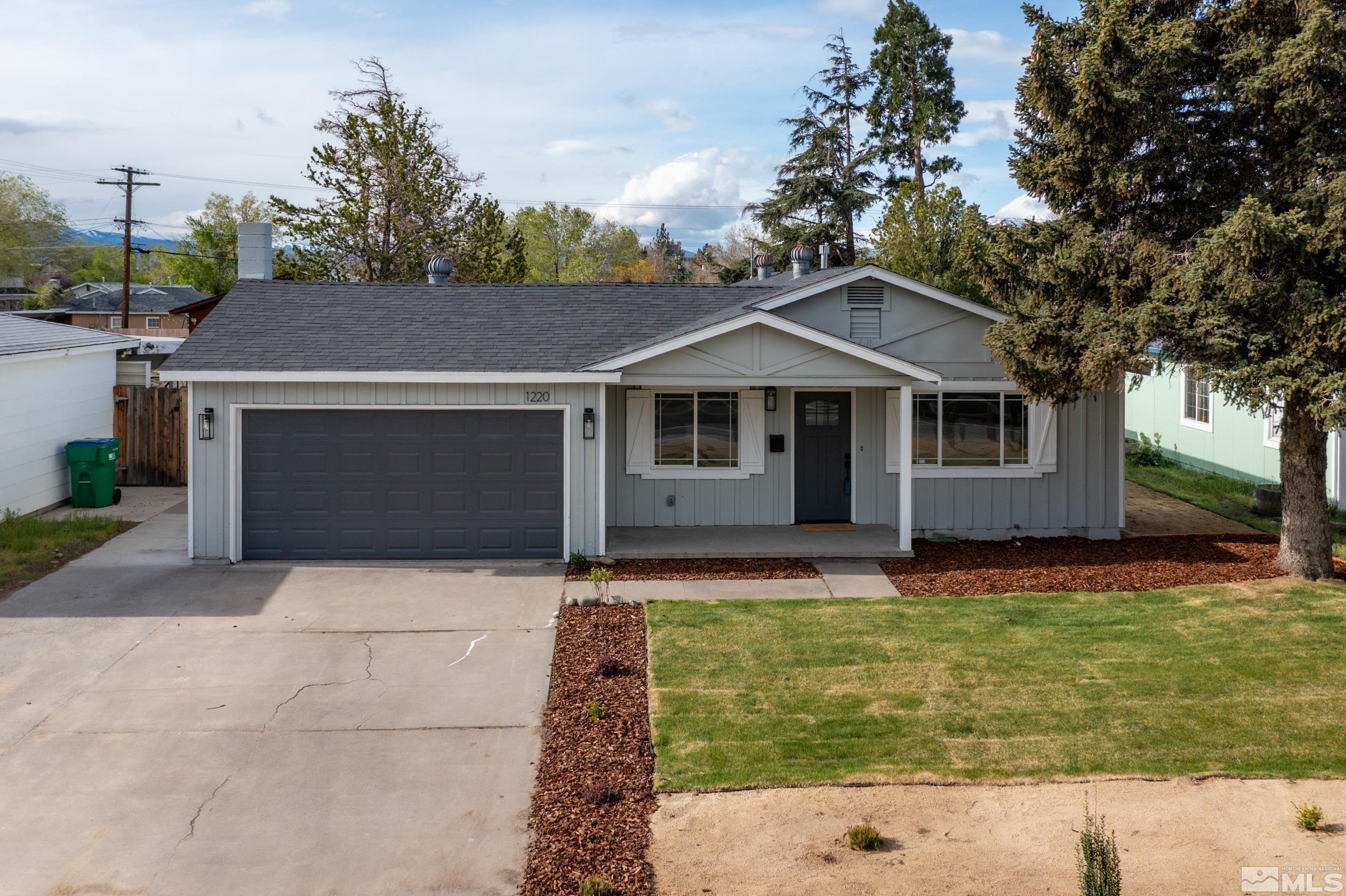 1220 Vassar Street Reno, NV 89502 - Photo 1 of 36 a front view of a house with a garden and trees