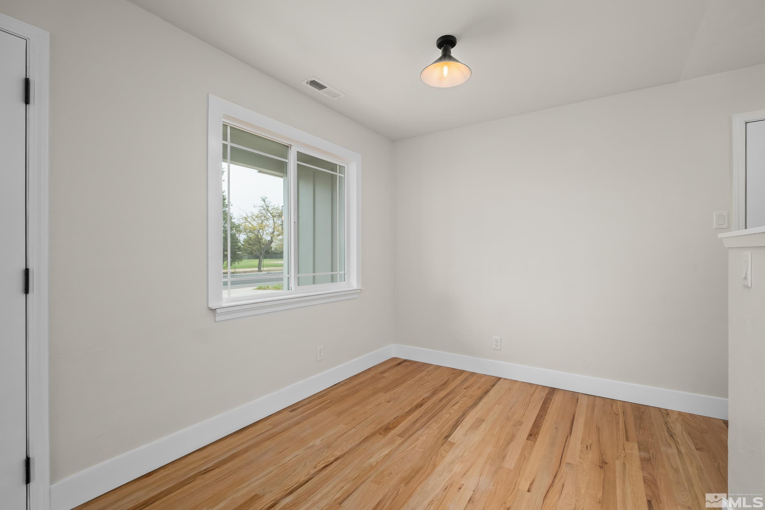 1220 Vassar Street Reno, NV 89502 - Photo 11 of 36 an empty room with wooden floor and windows