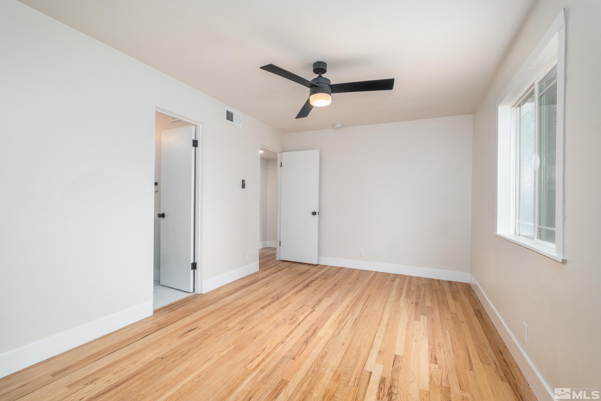 1220 Vassar Street Reno, NV 89502 - Photo 14 of 36 a view of empty room with wooden floor and fan