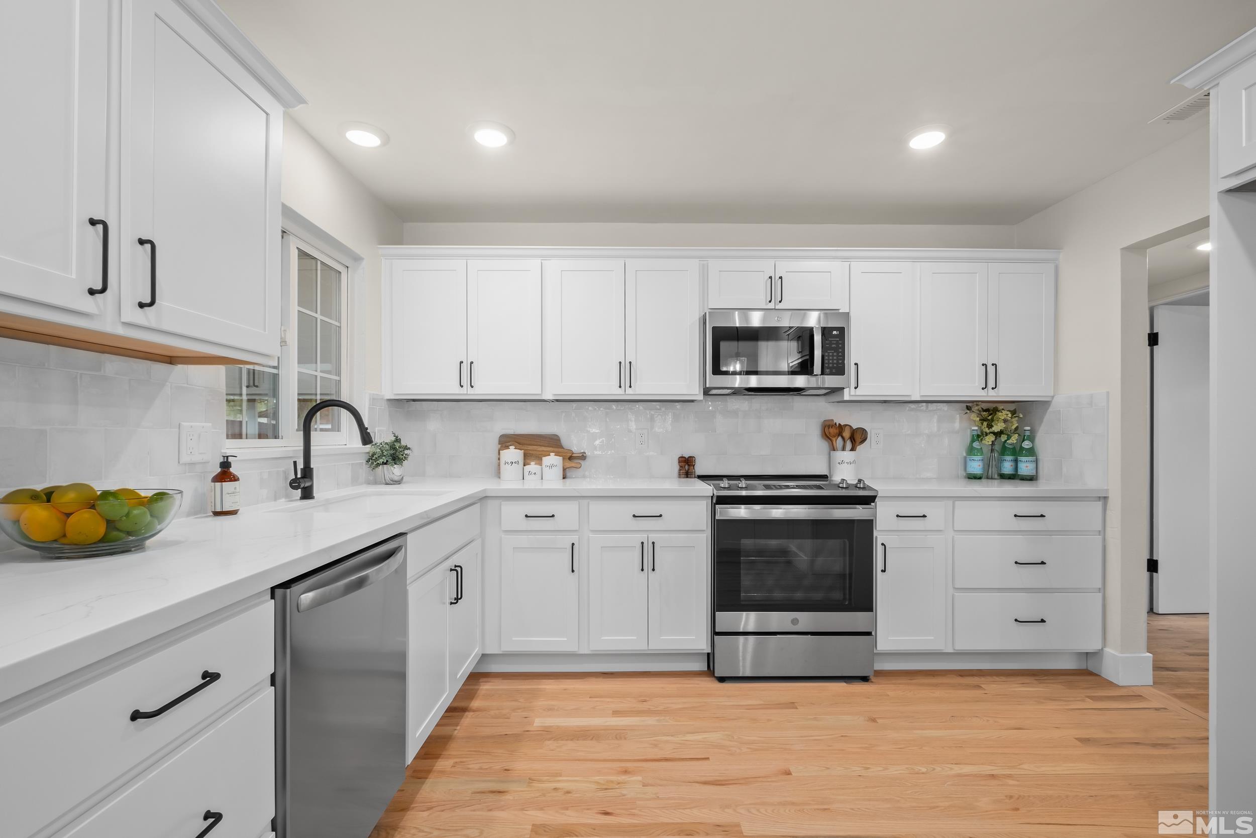 1220 Vassar Street Reno, NV 89502 - Photo 3 of 36 a kitchen with stainless steel appliances granite countertop a sink a stove and cabinets