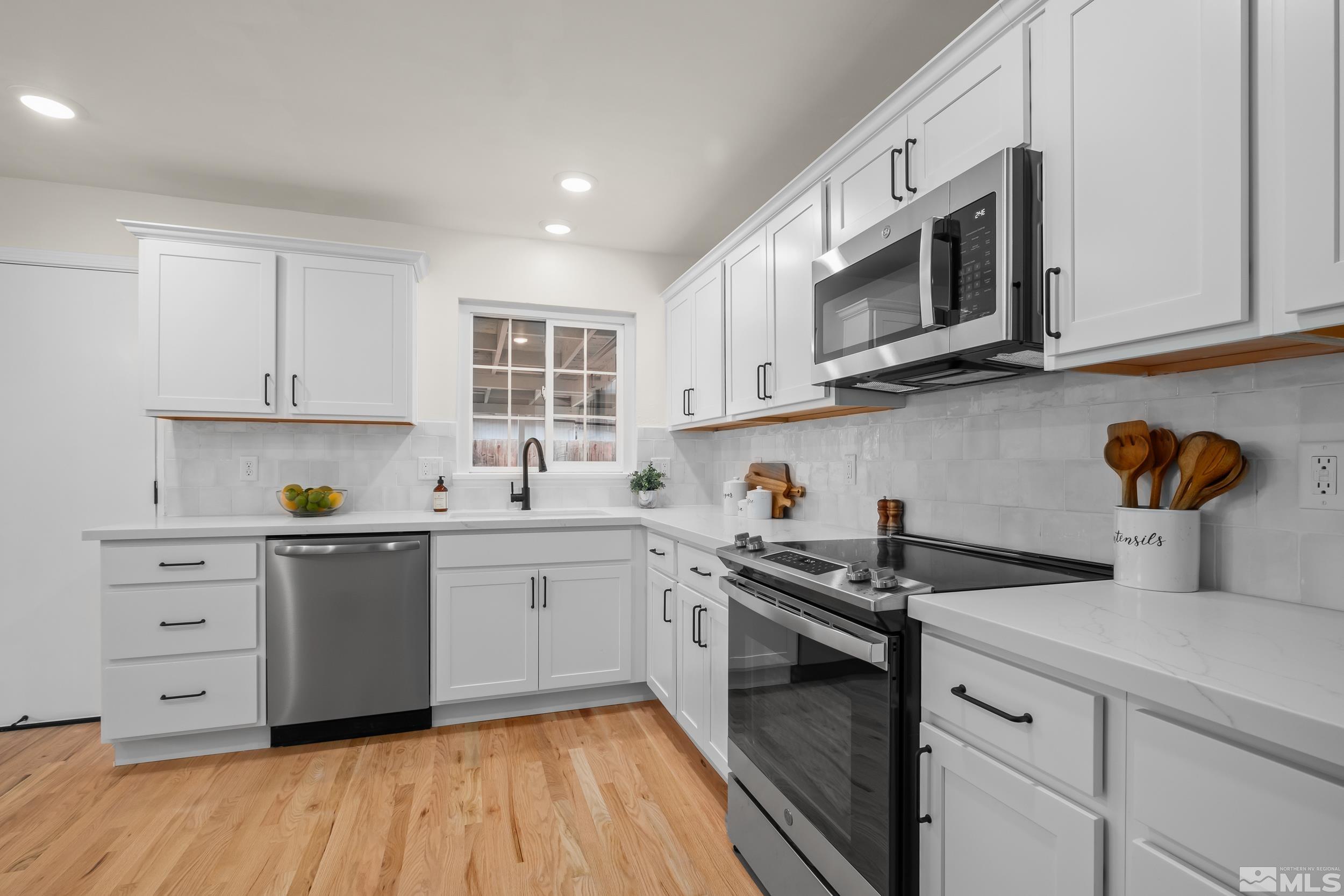 1220 Vassar Street Reno, NV 89502 - Photo 5 of 36 a kitchen with stainless steel appliances granite countertop a sink and a stove top oven