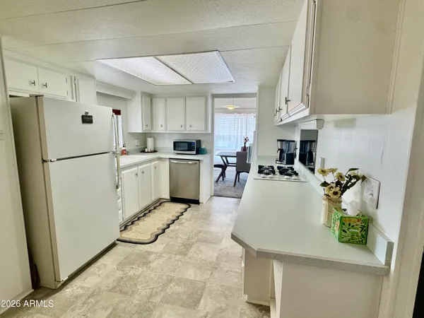 a kitchen with refrigerator and white cabinets