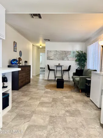a living room with furniture a rug and kitchen view