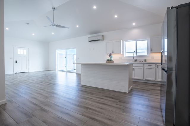 a kitchen with stainless steel appliances granite countertop wooden floors and view living room
