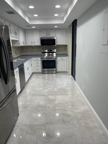 a kitchen with stainless steel appliances a refrigerator sink microwave and cabinets