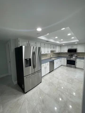 a kitchen with stainless steel appliances granite countertop a refrigerator and a stove