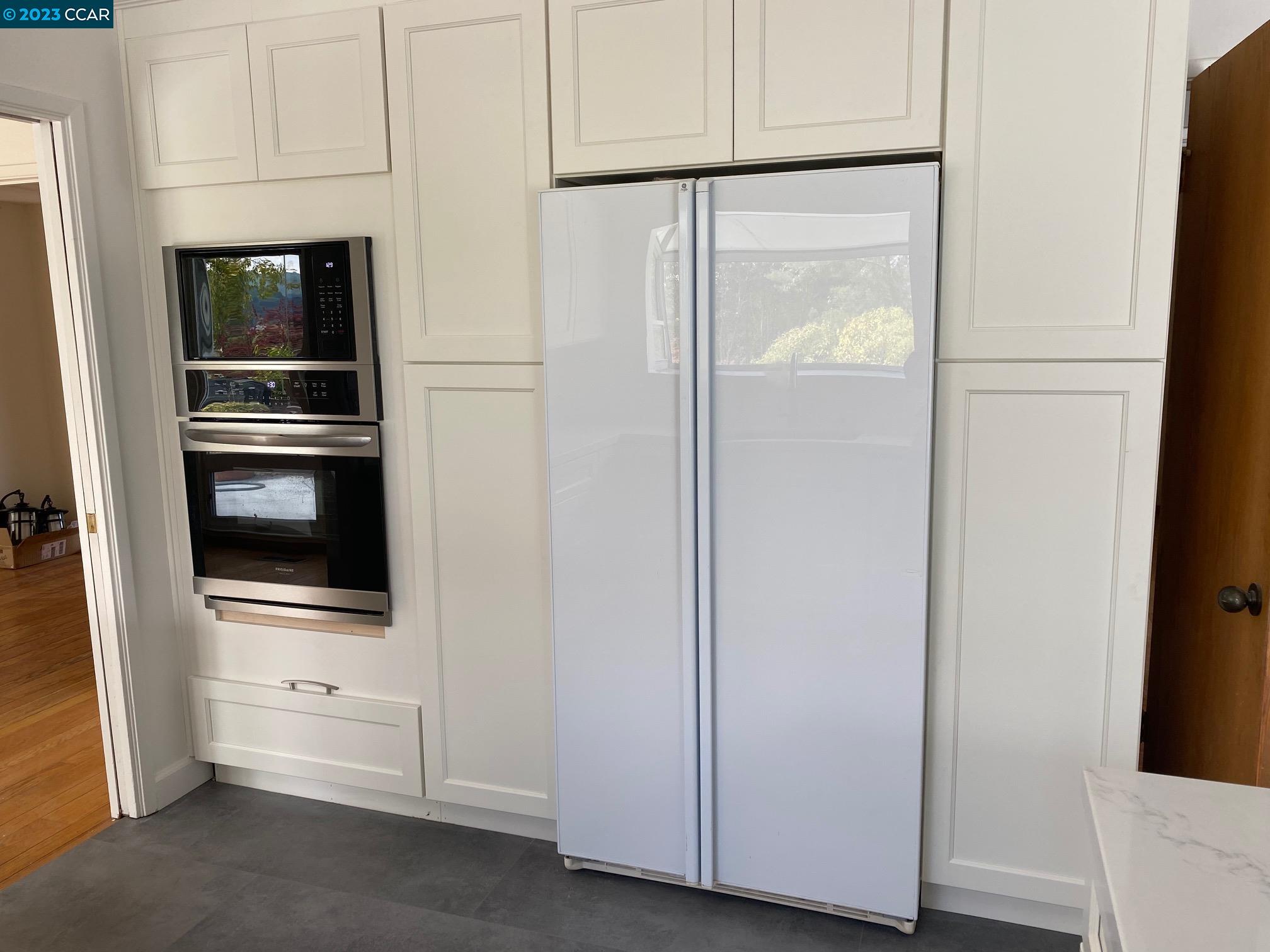 45 Sullivan Drive Moraga, CA 94556 - Photo 8 of 12 a view of a refrigerator and an empty room with wooden floor