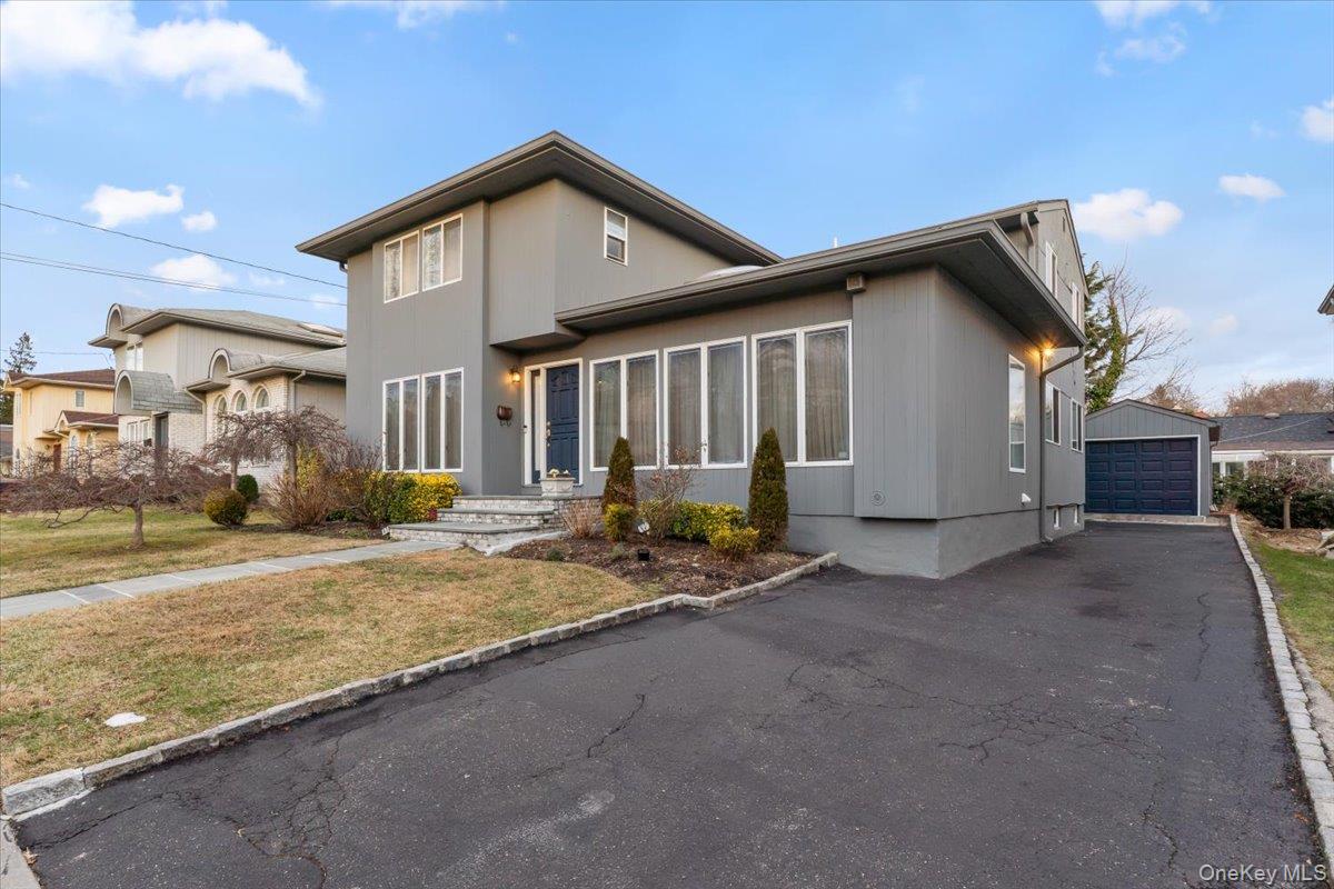 47 Berkshire Road Great Neck, NY 11023 - Photo 2 of 40 View of front of home with a detached garage, an outdoor structure, and a front yard