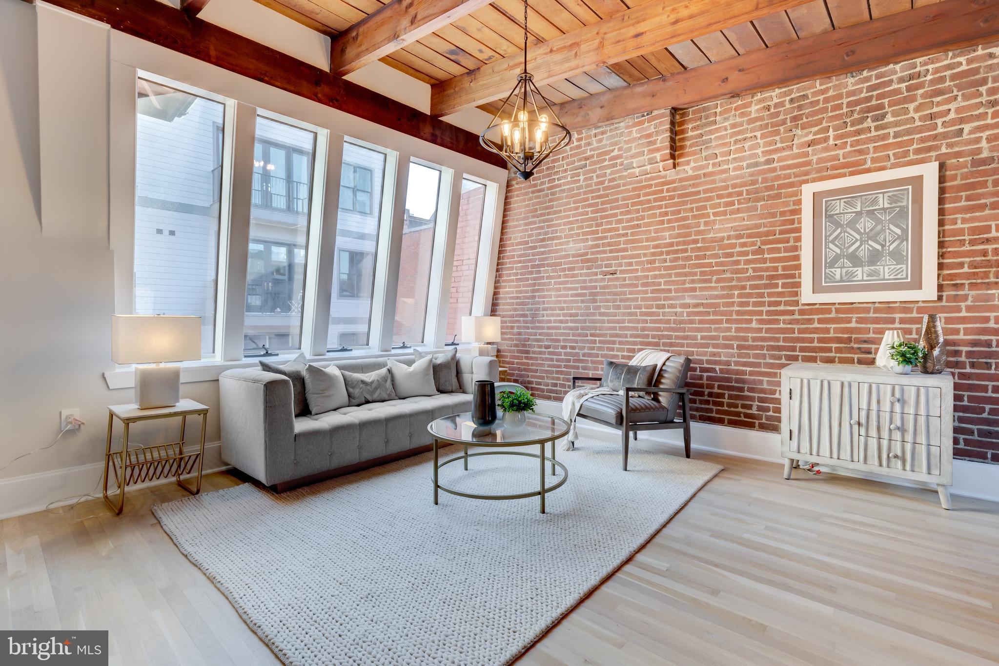 1314 Vermont Avenue Northwest, Unit CH6 Washington, DC 20005 - Photo 1 of 23 a balcony with couch and wooden floor