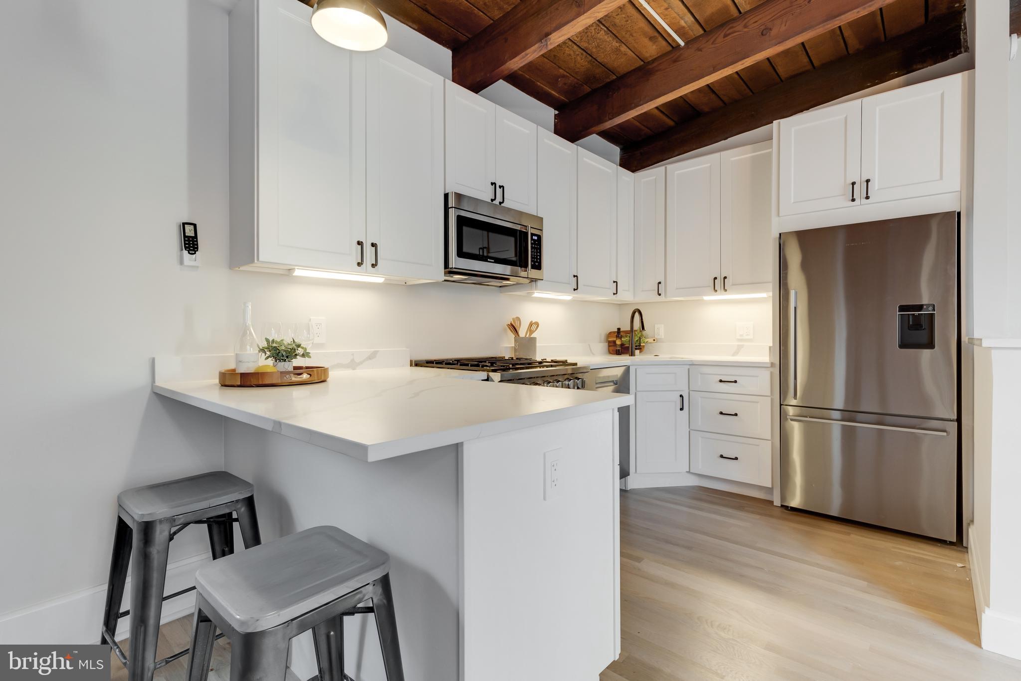 1314 Vermont Avenue Northwest, Unit CH6 Washington, DC 20005 - Photo 12 of 23 a kitchen with stainless steel appliances a refrigerator stove microwave and cabinets