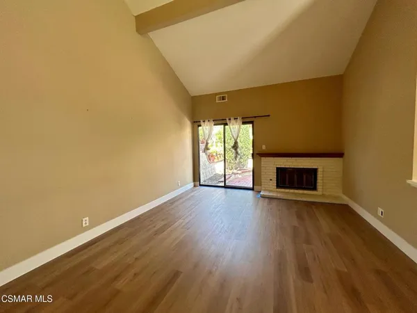 an empty room with wooden floor and fireplace