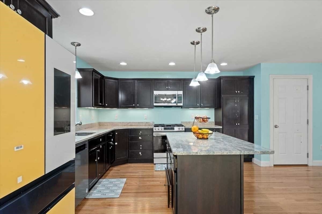 28 McIntosh Drive, Unit 22 Stow, MA 01775 - Photo 15 of 38 a kitchen with a sink a counter top space and living room view