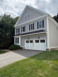 28 McIntosh Drive, Unit 22 Stow, MA 01775 - Photo 2 of 38 a front view of a house with a garden and yard