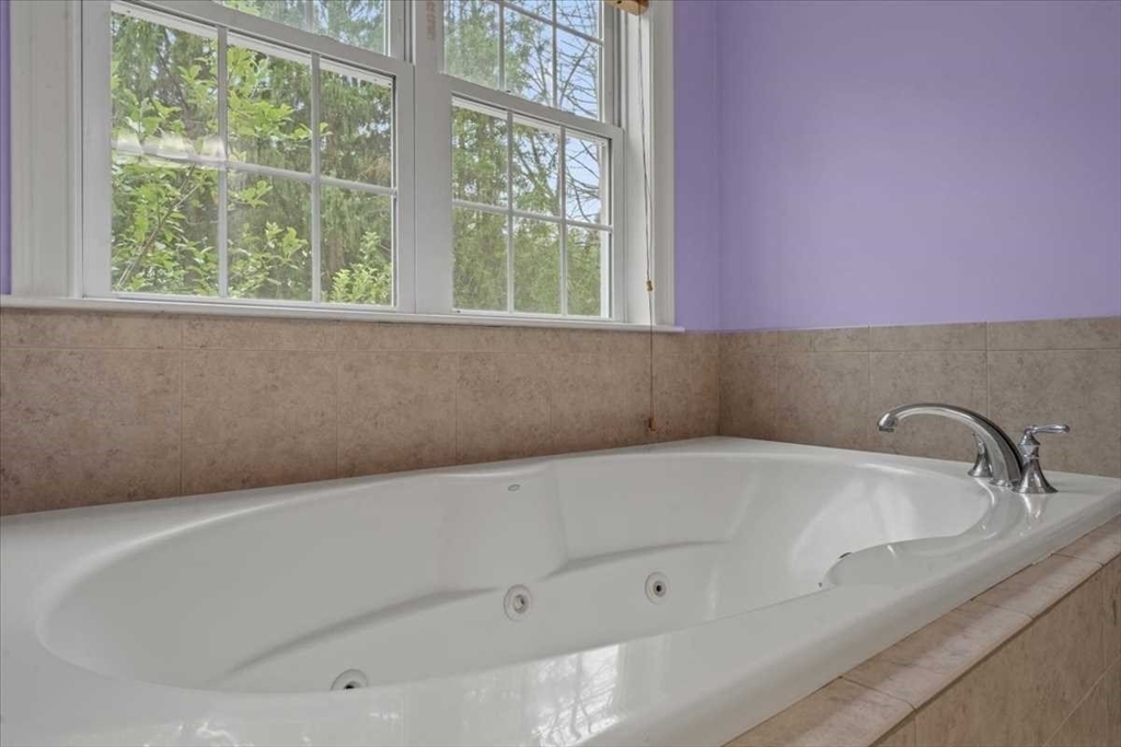 28 McIntosh Drive, Unit 22 Stow, MA 01775 - Photo 24 of 38 a bath tub sitting in a bathroom next to a window