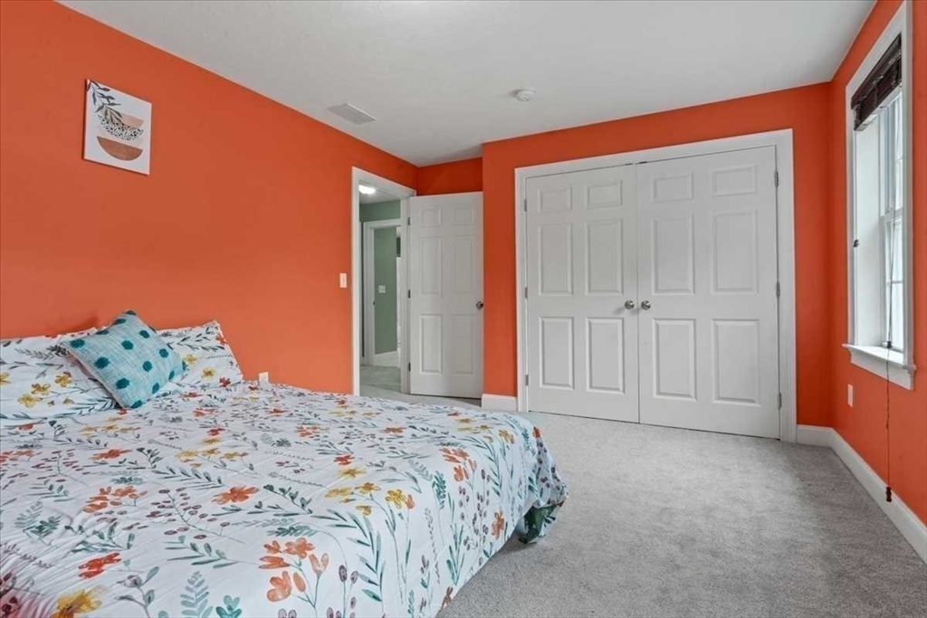 28 McIntosh Drive, Unit 22 Stow, MA 01775 - Photo 26 of 38 a bedroom with a bed and a painting on the wall