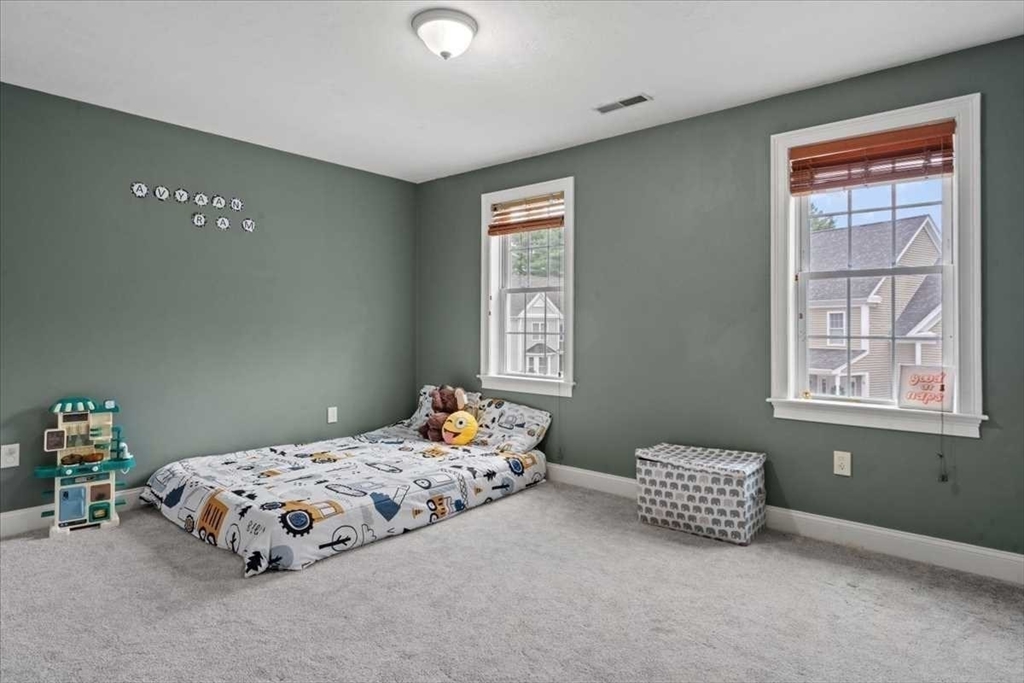 28 McIntosh Drive, Unit 22 Stow, MA 01775 - Photo 28 of 38 a bedroom with a bed and a window