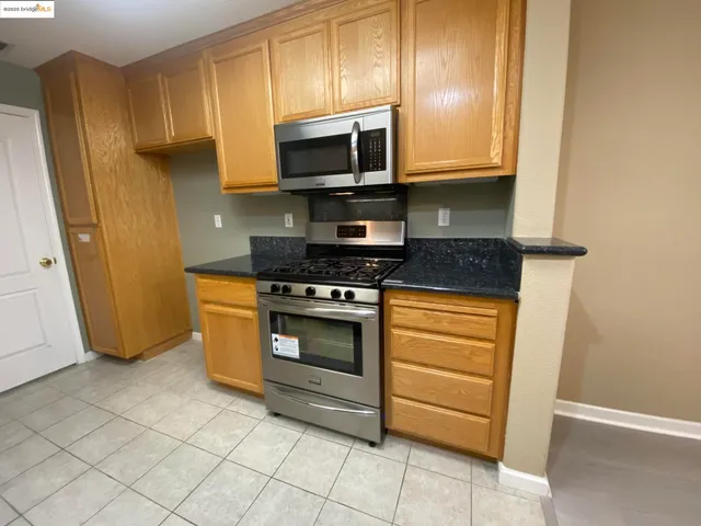 a kitchen with stainless steel appliances granite countertop a stove a microwave and a refrigerator